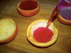 Pouring jelly into orange peel halves